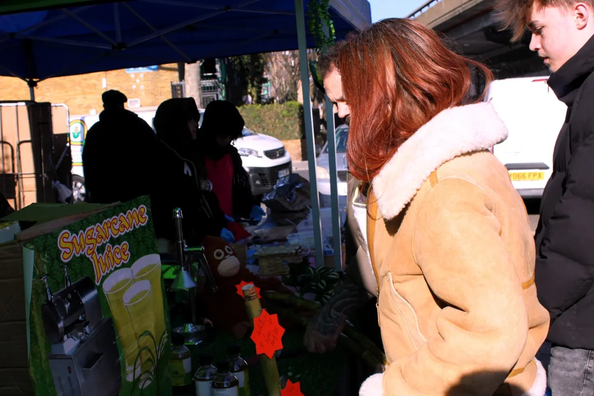 Customers stopping at the stall to look at the bottles and prices